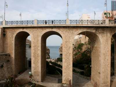 Ritorniamo allora sui nostri passi: davanti a noi si stagliano gli ampi archi in tufo del ponte borbonico che lasciano intravedere il mare e la scogliera sullo sfondo
